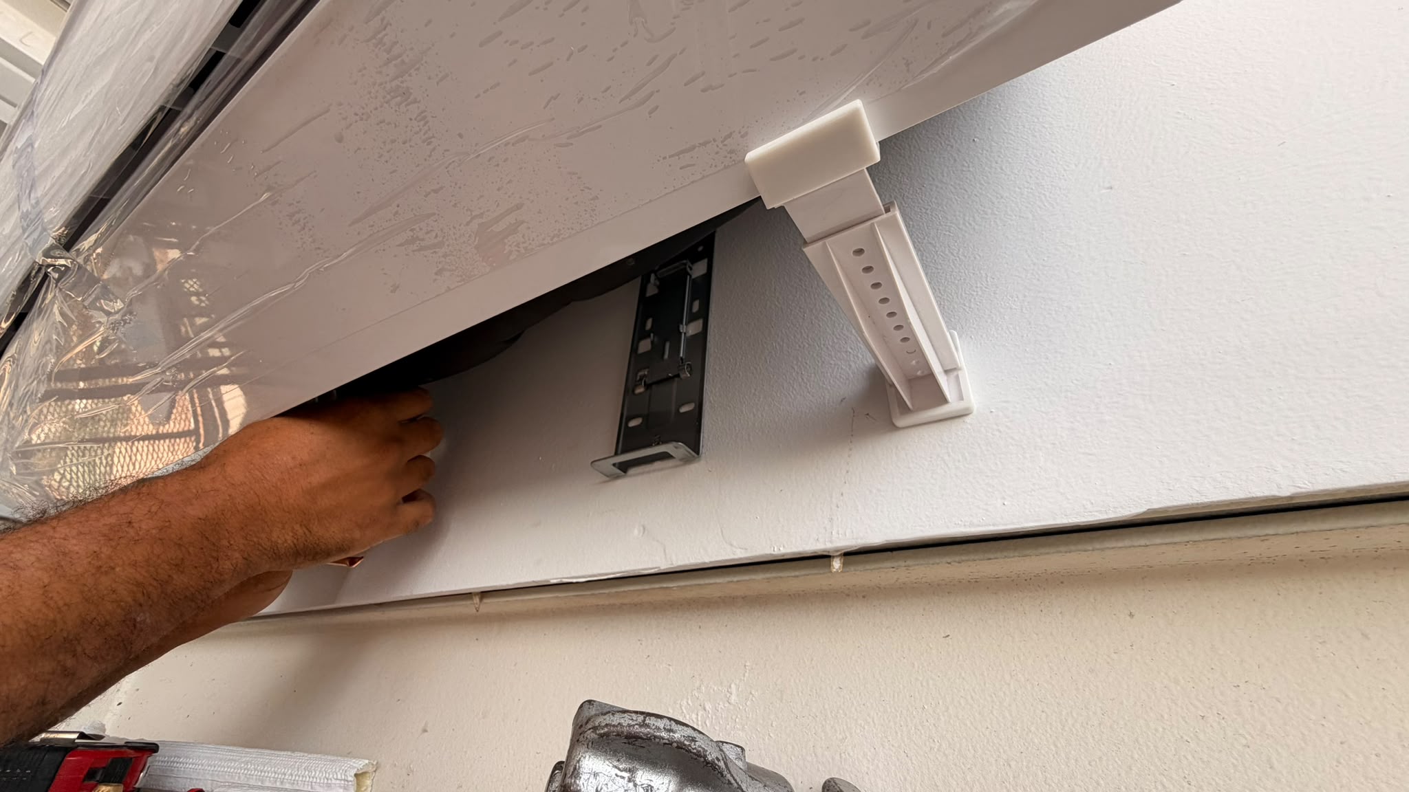 Instalador colocando el soporte unamano en un split